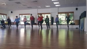 קבוצת נשים מאוזנות על רגל אחת בתרגול צ'י קונג בסטודיו